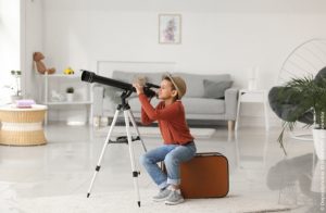 Junge benutzt ein Kinder Teleskop